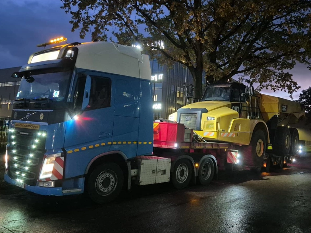 Camion Volvo si semitrailer transportand o autobasculanta pentru santiere